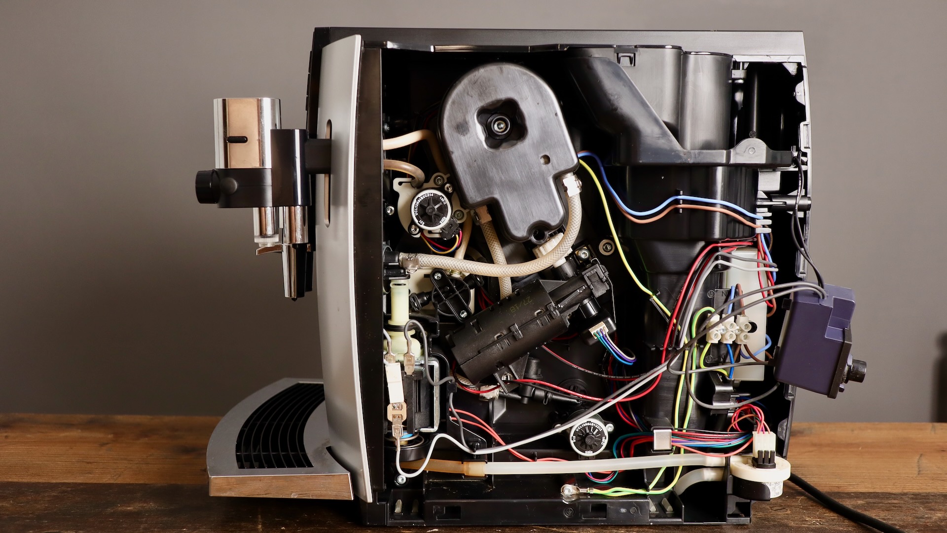 Jura E8 espresso machine with right cover off, showing grinder, motor, water counter, etc.