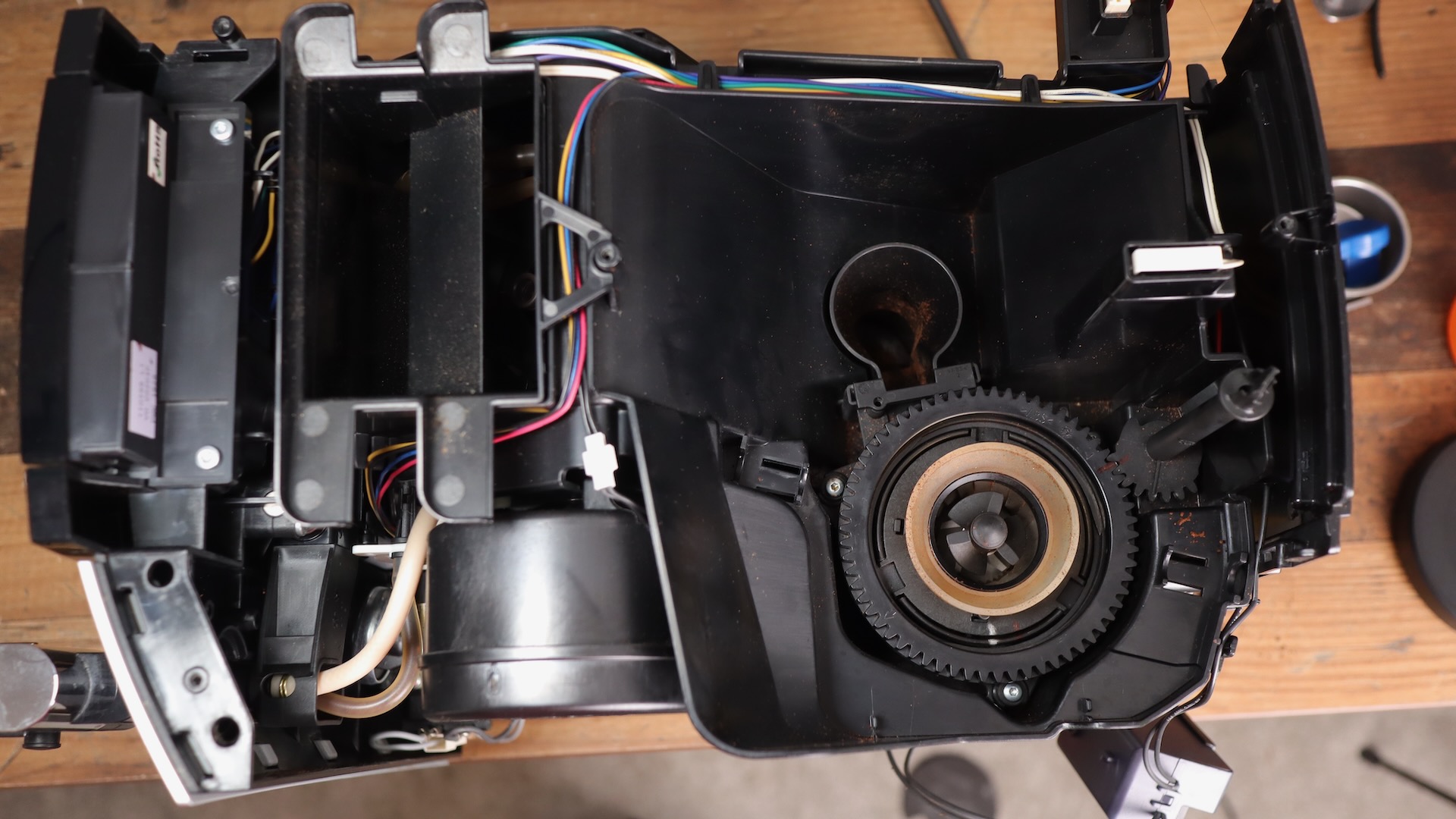 Top view with cover off on the Jura E8 espresso machine, exposing the grinder and grinds chute