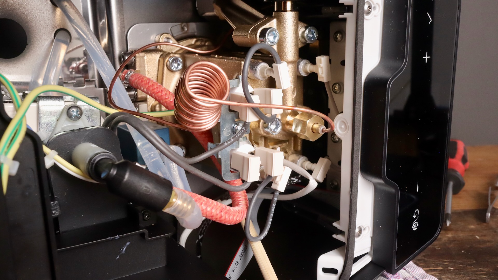 Inside of Gaggia Classic Up, showing brass boiler, pump, over pressure valve, manometer line, and more